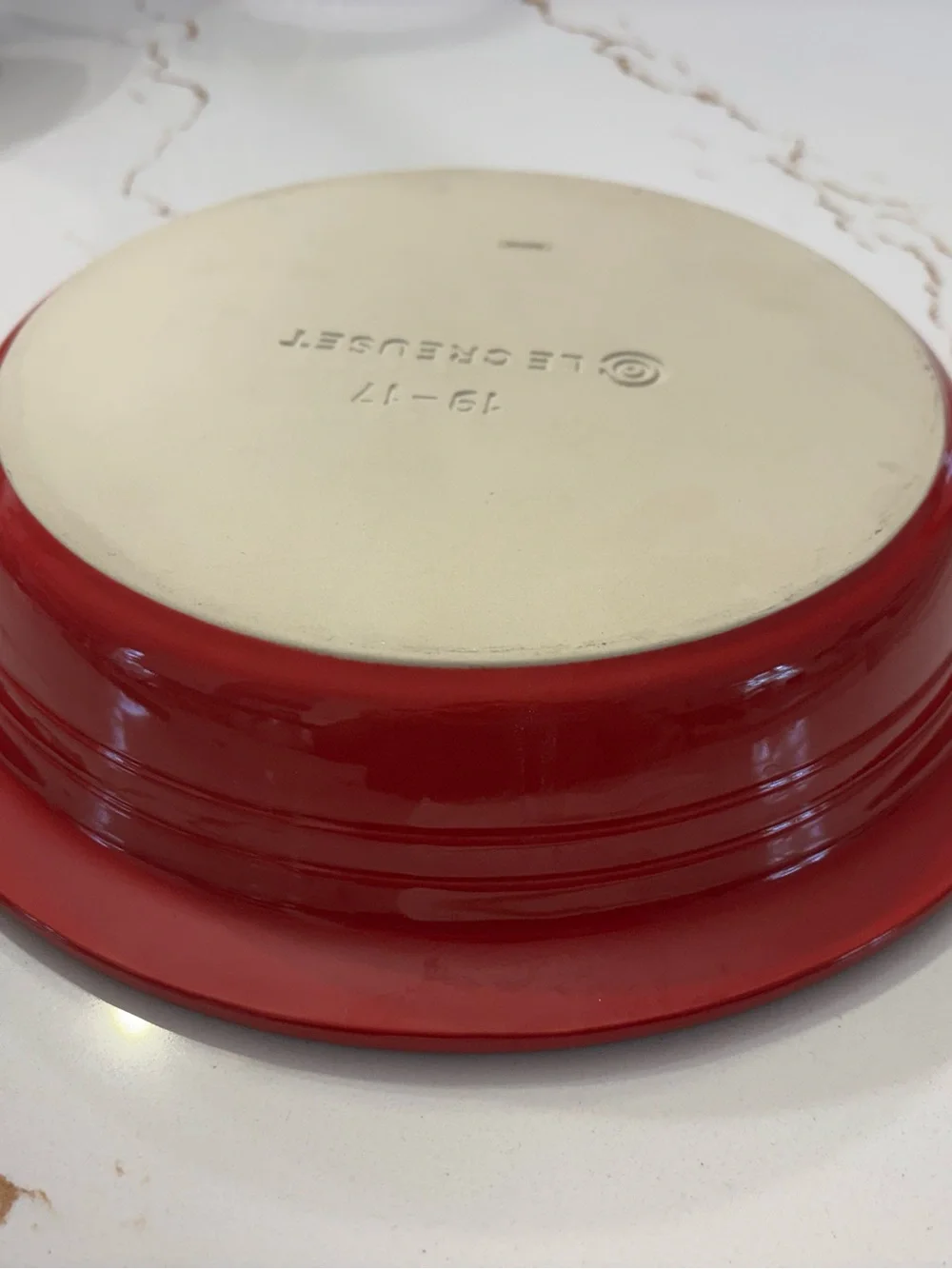 Le Creuset Cerise Red pie baking dish featuring a cream-colored interior.